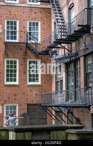 Backsteinhaus mit vielen Feuerausbrüchen hinter dem Friedhof von King's Chapel Burying Ground, Tremont Street, Boston, Massachusetts, USA Stockfoto