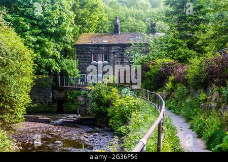 Ein Haus liegt in einem Wald am Fluss Calder in der Nähe der Hebden Bridge, Yorkshire, Großbritannien. Stockfoto