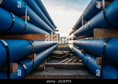 Gussrohre in Stapel für Kanalisation bereit für Transport und Logistik. Stockfoto