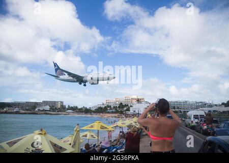 Sint Maarten, Niederländische Antillen - 01. Januar 2016: Touristen beobachten vom Strand aus, wie das Flugzeug auf dem Princess Juliana International Airport in St. Maa landet Stockfoto