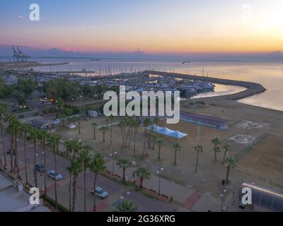 Top Luftaufnahme mit Blick auf die Pause des Tages im Hafen von Larnaca Altstadt, Zypern. Yachten im Mittelmeer, Volleyballplatz am Strand. Stockfoto