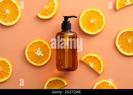 Bernsteinfarbene Glas-Pumpflasche mit natürlichem Shampoo mit vitaminC C und orangefarbener Draufsicht. Stockfoto