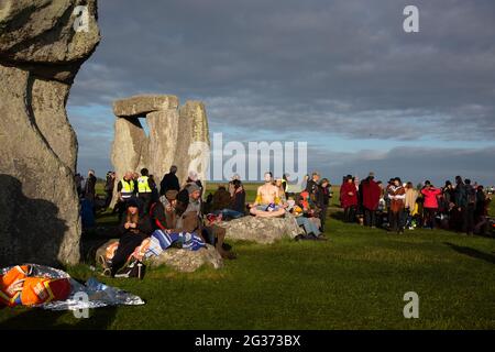 Ein Mann meditiert auf einem der heiligen Steine des Stonehenge-Denkmals in Wiltshire, Großbritannien. --- der 21. Juni ist der Tag der Sommersonnenwende. Es ist das Stockfoto