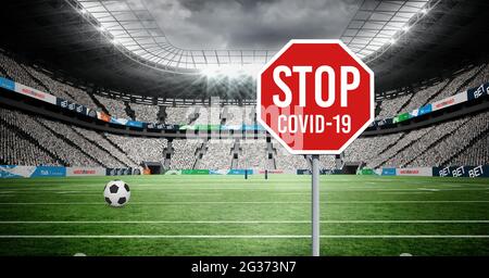 Zusammensetzung von Fußball und Virus und Warnung Straßenschild über Sportstadion Stockfoto