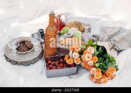 Sommer Picknick Essen, Mittagessen im Freien im Park. Picknick im Sommer mit Erdbeeren, Obst, Croissants, Kekse, Wein, Saft auf dem Hintergrund der Decke Stockfoto