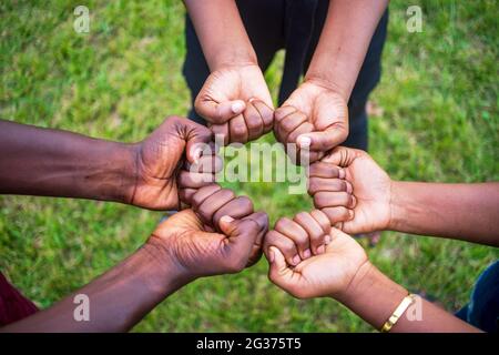 Teamwork-Konzept mit unterschiedlicher Hautfarbe Menschen berühren ihre Fäuste Stockfoto