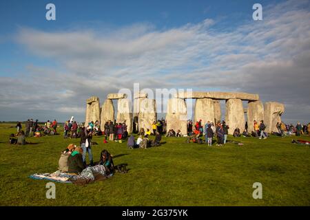 Nachtschwärmer feiern die Sommersonnenwende unter den alten Steinen des neolithischen Denkmals Stonehenge auf der Salisbury Plain, England, Großbritannien. Stockfoto