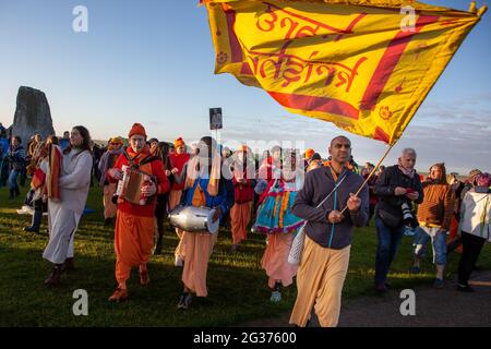 Hare Krishnas gehören zu den Feiernden, die die Sommersonnenwende unter den alten Steinen des neolithischen Denkmals Stonehenge in England feiern. Stockfoto