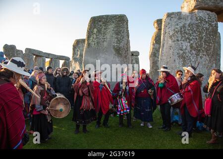 Nachtschwärmer feiern die Sommersonnenwende unter den alten Steinen des neolithischen Denkmals Stonehenge auf der Salisbury Plain, England, Großbritannien. Stockfoto