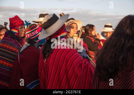 Peruanische Sonnenanbeter treffen sich zu den Feiernden, die die Sommersonnenwende unter den alten Steinen des neolithischen Denkmals Stonehenge, England, feiern. Stockfoto