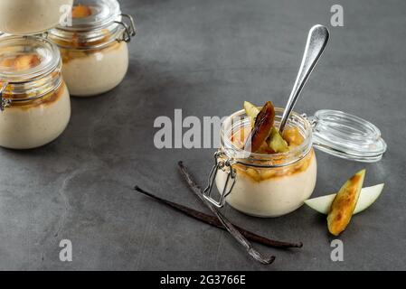 Apfel- und Zimtpudding in einem Glasgefäß auf dunklem Steingrund Stockfoto