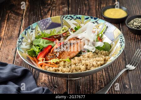 Gegrillter Lachs mit Quinoa-Salat auf brauner Schüssel. Stockfoto