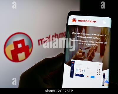 Person, die Mobiltelefon mit Website des singapurischen Fintech-Unternehmens MatchMove Pay Pte Ltd auf dem Bildschirm mit Logo hält. Konzentrieren Sie sich auf die Mitte des Telefondisplays. Stockfoto