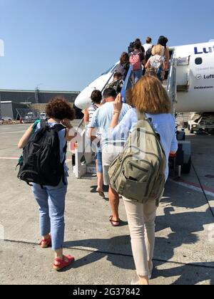 Touristen-Passanten, die am Flughafen in ein Flugzeug steigen.Sommerferien. Stockfoto