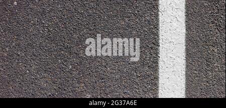 Asphaltstruktur mit weißer Linie auf der rechten Seite. Fahrbahnbelag mit Markierungen. Stockfoto