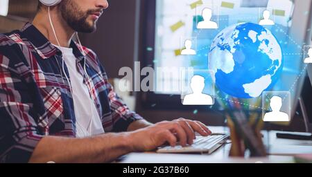 Netzwerk von Profilsymbolen auf der ganzen Welt gegen den mittleren Teil des Mannes, der Computer im Büro benutzt Stockfoto