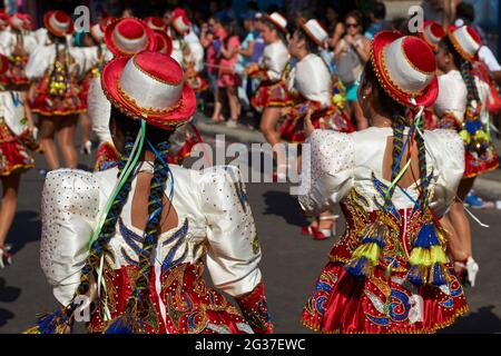 Weibliche Mitglieder einer Caporales-Tanzgruppe in kunstvollen Kostümen, die beim jährlichen Karneval Andino con la Fuerza del Sol in Arica, Chile, auftreten Stockfoto