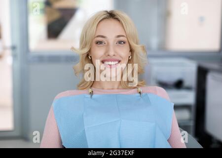 Blonde junge Frau Patient lächelt in der Zahnmedizin Stockfoto