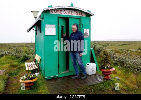 Cola-Sjalfsali, Coca-Cola-Automatenhut, grüne Hütte, Frau, Borgarfjaroarvegur, Island Stockfoto