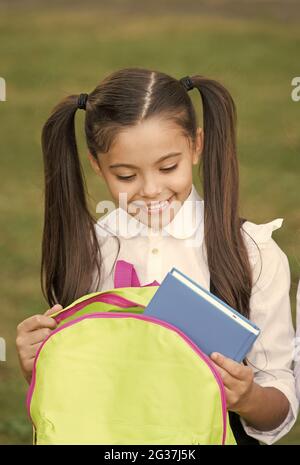 Schulmädchen Putting Buch in Rucksack, bereit für den Unterricht Konzept Stockfoto