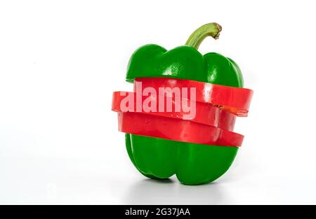Geschnittene nasse rote und grüne Paprika oder Paprika auf weißem Hintergrund, in Scheiben schneiden und durch zwei grüne Teile oben und unten neu anordnen und rote Teile sind in der Hälfte Stockfoto