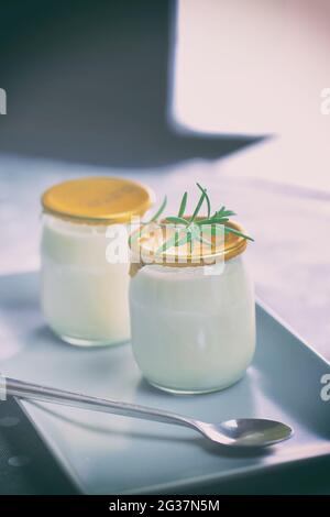 Joghurt in einem Glas mit einem Löffel. Gesunde Lebensmittel zum Frühstück, Milchprodukte Stockfoto