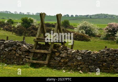 Holzstile über einer trockenen Steinmauer im Ubley Warren Naturschutzgebiet auf den Mendip Hills in Somerset UL Stockfoto