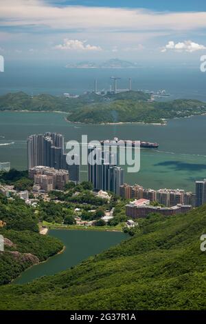 Ein Schiff im East Lamma Channel dampft an den luxuriösen Hochhäusern der Residence Bel-air in Pok Fu Lam auf Hong Kong Island vorbei Stockfoto