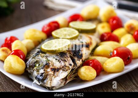 Gebackene Seebrasse mit Babykartoffeln und Kirschtomaten Stockfoto