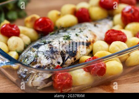 Gebackene Seebrasse mit Babykartoffeln und Kirschtomaten Stockfoto