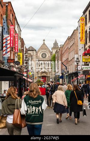 Einkaufslustige in der Fußgängerzone der belebten Anne Street South mit Blick nach Osten in Richtung St. Ann's Church of Ireland in Dublin, Irland Stockfoto