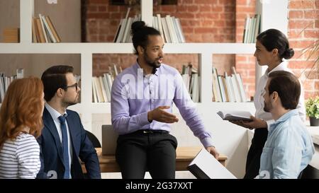 Junger seriöser afroamerikanischer Chef, der ein Brainstorming-Treffen leitet. Stockfoto