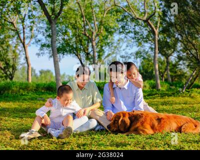 Glückliche Familie von vier und Hund spielen im Park qualitativ hochwertige Foto Stockfoto