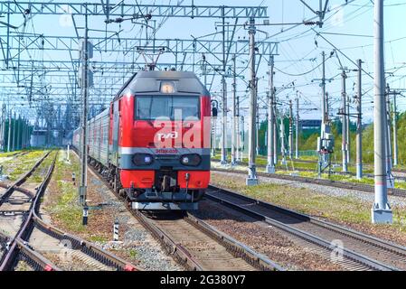 REGION LENINGRAD, RUSSLAND - 24. MAI 2021: Russische 6-Achs-DC-Passagierlokomotive EP2K-035 mit Personenzug an einem sonnigen Maitag Stockfoto