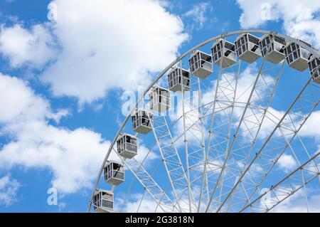 Riesenrad an einem sonnigen Tag mit weißen Wolken Stockfoto