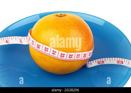 Eine gesunde Ernährung Gewichtsverlust Konzept, eine Grapefruit mit einem Maßband um sie gewickelt. Stockfoto