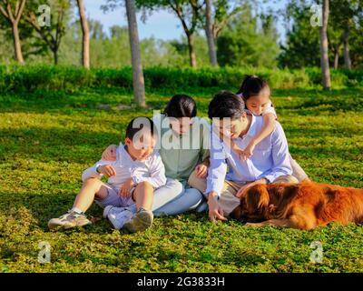 Glückliche Familie von vier und Hund spielen im Park qualitativ hochwertige Foto Stockfoto