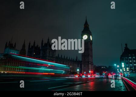 Big Ben London England bei Nacht. Big Ben bei Nacht. Mit leichten Trails. London, Großbritannien. Roter Bus in Bewegung und Big Ben in der Nacht. Roter Bus in Bewegung und BI Stockfoto