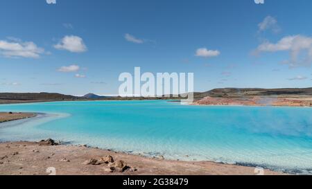 Blauer See in Hverir Myvatn Geothermie-Gebiet mit kochenden Schlammbecken und dampfenden Fumarolen in Island Stockfoto