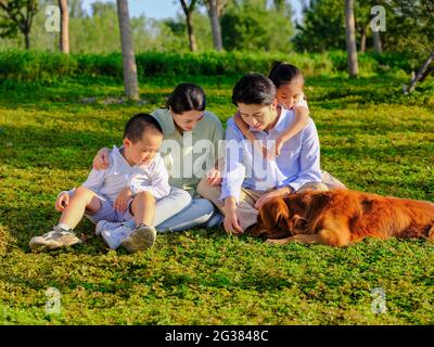 Glückliche Familie von vier und Hund spielen im Park qualitativ hochwertige Foto Stockfoto