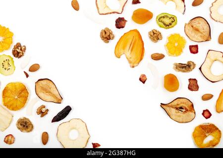 Oben sehen Zusammensetzung von getrockneten Früchten Äpfel, Orange, Kakimmon, Kiwi, Aprikosen und Nüsse auf weißem Hintergrund. Konzept der richtigen Ernährung mit leckeren getrockneten Früchten und Nüssen. Stockfoto