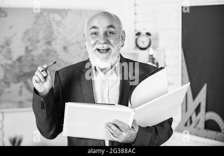 Gute Idee zu studieren. Zurück zur Schule. Matheausbildung in der Schule. Bärtiger Mann geben Markierungen. Schreiben Sie Notizen im Buch. Glückliche Senior Dozent machen Notizen. Lehrer Stockfoto