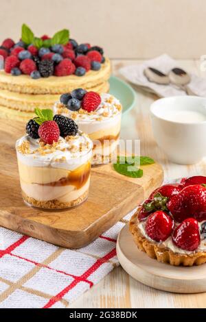 Süße Desserts mit frischen Beeren auf Holzhintergrund. Stockfoto