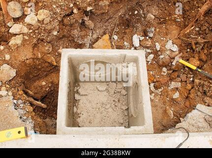 Eine Abwasserinspektionskammer oder ein Brunnen auf einer Baustelle. Es ist noch nicht mit dem Gebäude für irgendwelche Rohre verbunden. In Der Provinz Udine, Friaul-Julisch-Giuli Stockfoto