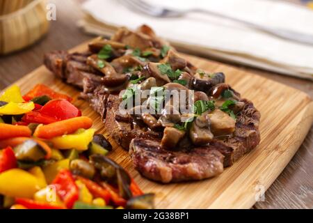 Gegrilltes Beefsteak mit Pilzen und gemischtem Gemüse. Stockfoto