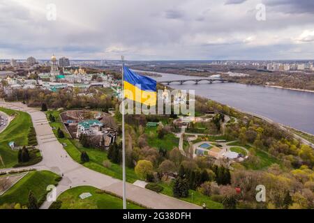 Luftaufnahme von oben durch Drohne der ukrainischen Flagge, die im Wind gegen die Stadt Kiew, Ukraine, winkt. Stockfoto