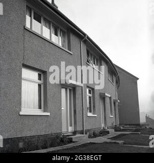 1966, historisch, Außenansicht des kürzlich erbauten Wohnheides der örtlichen Behörden, Hamilton Terrace, Fife, Schottland. Mit einem Beton- oder Zementaußenrender wurden diese Gebäude in dem stark, sogenannten 'brutalistischen' Architekturstil gebaut, der in dieser Zeit beliebt war. Vor der Haustür eines der Häuser, zwei Pint Milch. Stockfoto