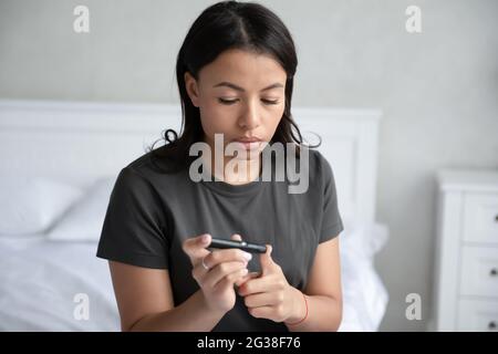 Schockiert verwirrt gemischt raste schwanger Mädchen Blick auf Teststock Stockfoto