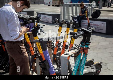 Moskau, Russland. 14. Juni 2021 EIN junger Mann bucht einen Elektroroller-Verleih im Zentrum von Moskau, Russland Stockfoto