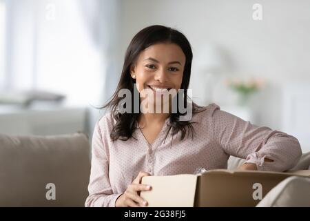 Glücklicher Kunde, der eine Bestellung vom Online-Shop erhält und das Paket auspackt Stockfoto